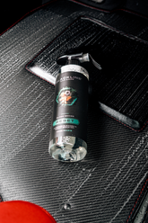Blackline Car Care RESET interior cleaner and scent booster in an orange bottle, placed on a clean car floor mat.