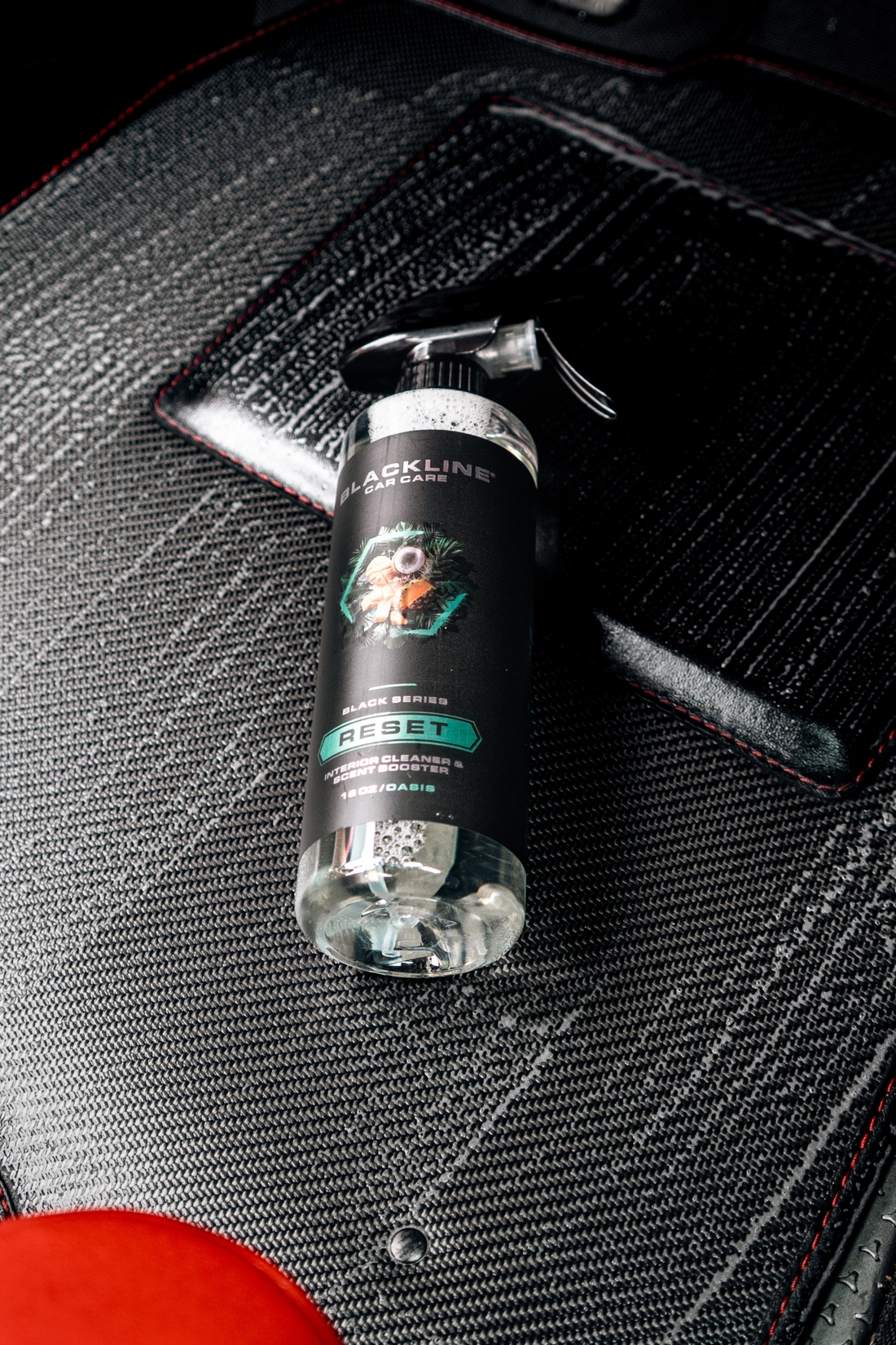 Blackline Car Care RESET interior cleaner and scent booster with a sleek black bottle and spray nozzle, displayed on a clean surface.