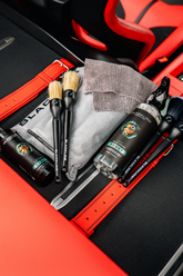 Blackline Car Care BLACKLINE® RESET interior cleaner and scent booster in a Ferrari F12 trunk, showcasing the product in a luxury vehicle.