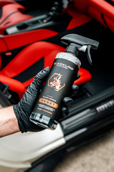 Blackline Car Care BLACKLINE® RESET interior cleaner and scent booster bottle with teakwood scent, held in hand.