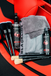 Blackline Car Care BLACKLINE® RESET interior cleaner and scent booster bottle in front of a Ferrari F12 seat with red upholstery