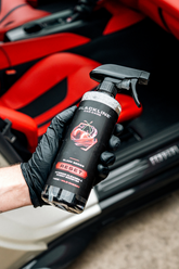 Blackline Car Care BLACKLINE® RESET interior cleaner and scent booster in wild cherry scent held in hand.
