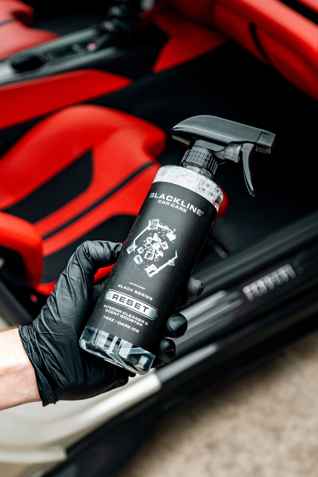 Blackline Car Care BLACKLINE® RESET interior cleaner and scent booster in hand, dark ice scent, for fresh vehicle interiors.