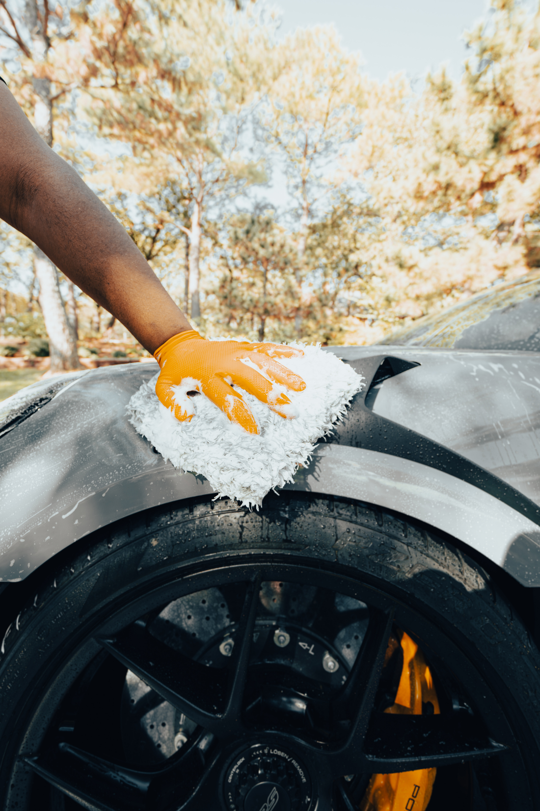 Blackline Car Care microfiber wash mitt in use, soft black microfiber material for gentle car washing.