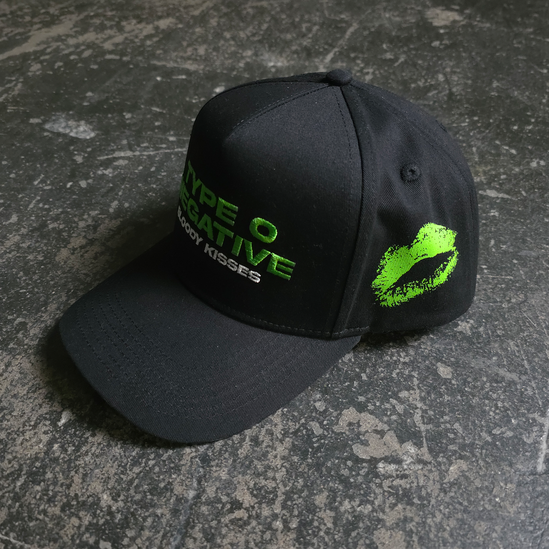 Black Bloody Kisses hat from Any Means Necessary Clothing featuring a graphic print and adjustable strap.