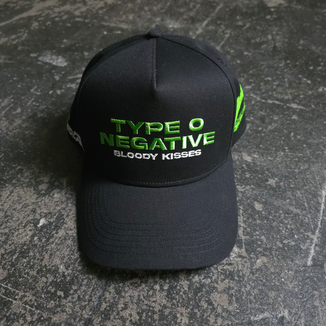 Black "Bloody Kisses" hat by Any Means Necessary Clothing featuring red blood splatter design and casual brim style.
