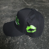 Black Bloody Kisses hat by Any Means Necessary Clothing featuring a bold graphic design and adjustable strap.