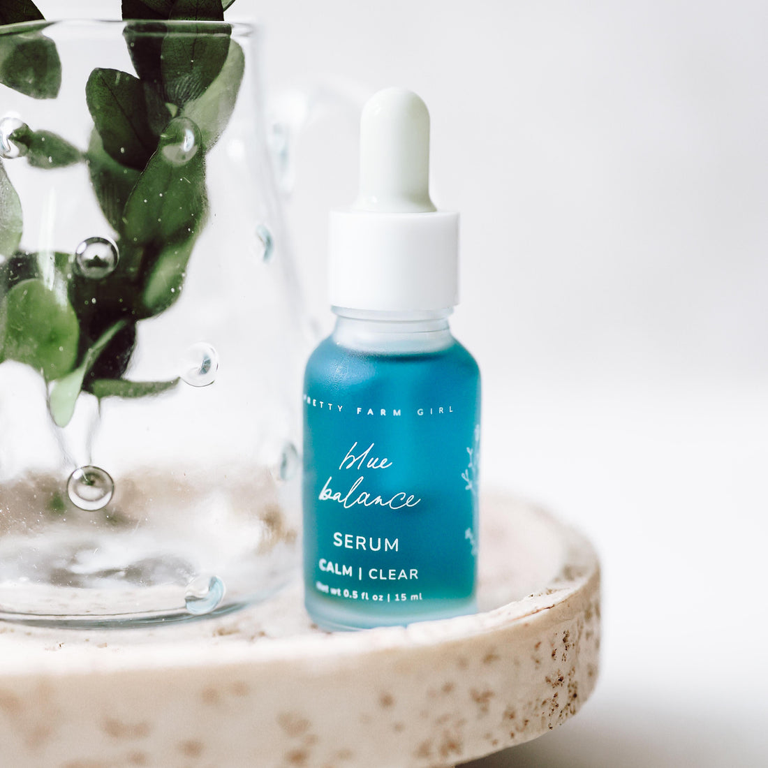 Blue Balance Face Serum by Pretty Farm Girl, featuring a sleek blue bottle with a dropper for skincare.