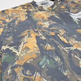 Close-up of Mayhem T-Shirt by Any Means Necessary Clothing featuring a camouflage design and bold graphic print.