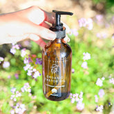 Pretty Farm Girl pure organic cold pressed castor oil in a clear glass bottle outdoors, showcasing natural castor oil product.