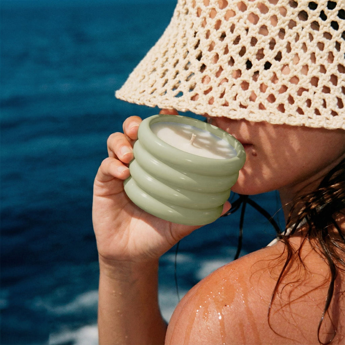 Soy wax ceramic candle from Italic featuring a white, minimalist ceramic holder with a lit wick and a soft, warm glow.