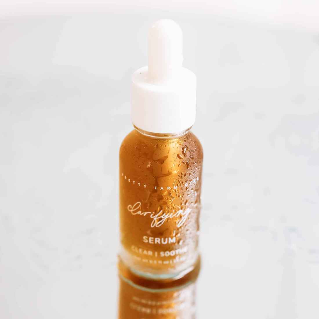Pretty Farm Girl clarifying face serum for acne-prone skin in a clear glass bottle with dropper applicator.