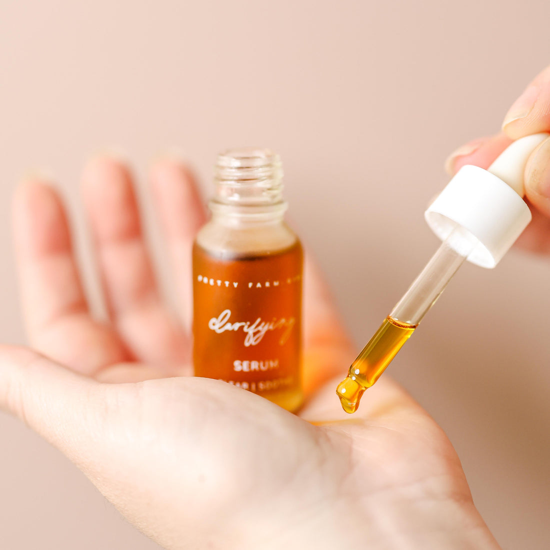 Bottle of Pretty Farm Girl clarifying face serum for acne-prone skin with dropper applicator on a white background.