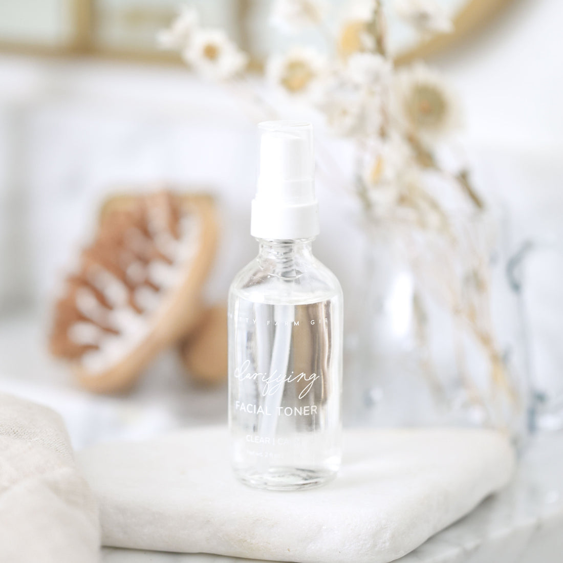 Bottle of Pretty Farm Girl Clarifying Hypochlorous Acid Toner with label, showing clear liquid inside a transparent container.