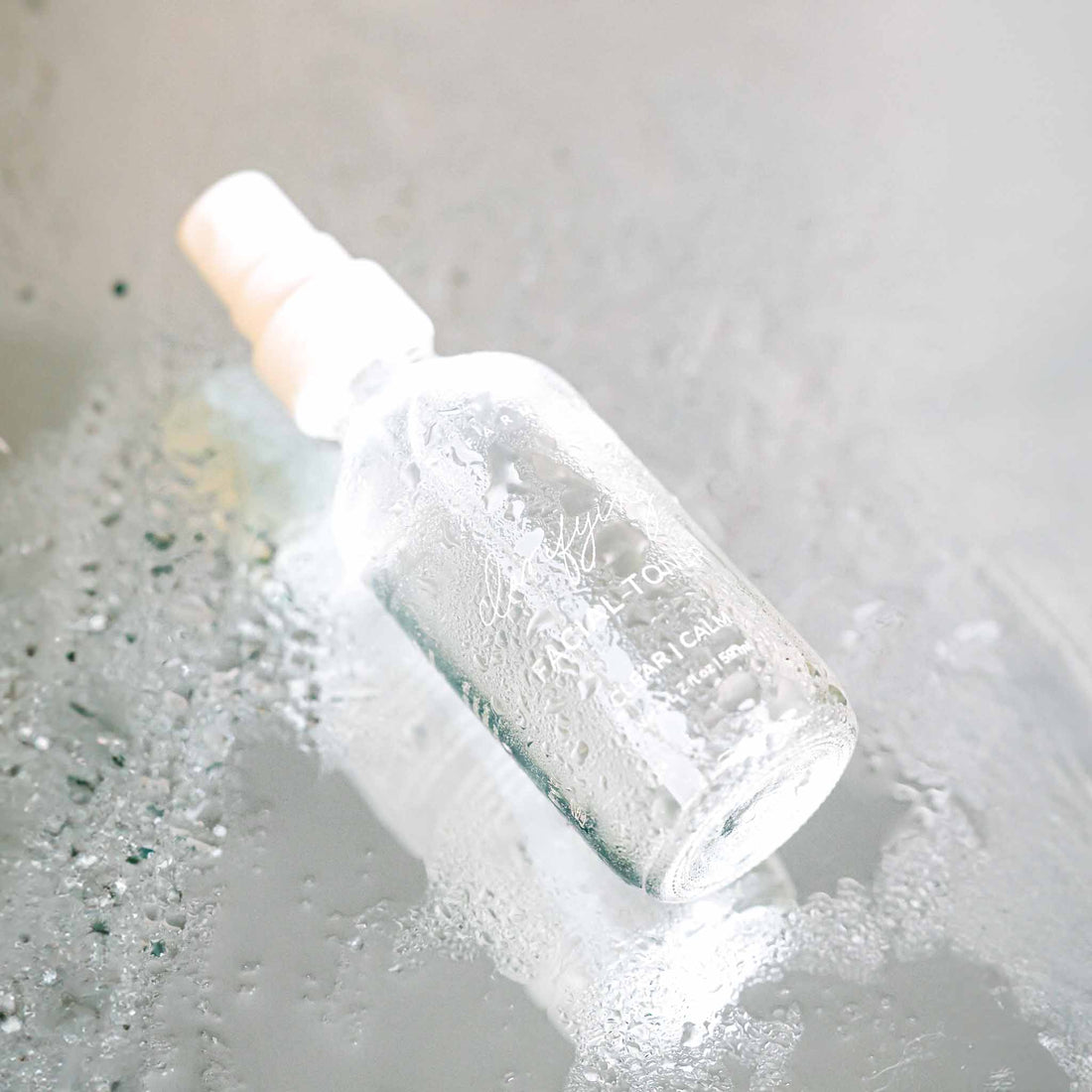 Pretty Farm Girl clarifying hypochlorous acid toner in a clear bottle, showing the transparent liquid and minimalist label.