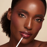 YENSA Luxe Lip Nourishing Oil with hyaluronic and vitamin E, a clear lip oil in a sleek tube, showing glossy finish and nourishing ingredients.