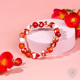 Feminine Force Carnelian Orca Agate bracelet by Conscious Items featuring orange and black patterned stone beads on a stretch cord.