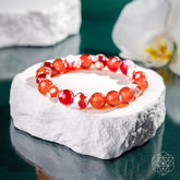 Feminine Force Carnelian Orca Agate bracelet by Conscious Items featuring vibrant orange and patterned agate beads on a elastic band.
