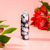 Spiritual Bodyguard Snowflake Obsidian Point home decoration by Conscious Items, featuring a polished black stone with white snowflake patterns.