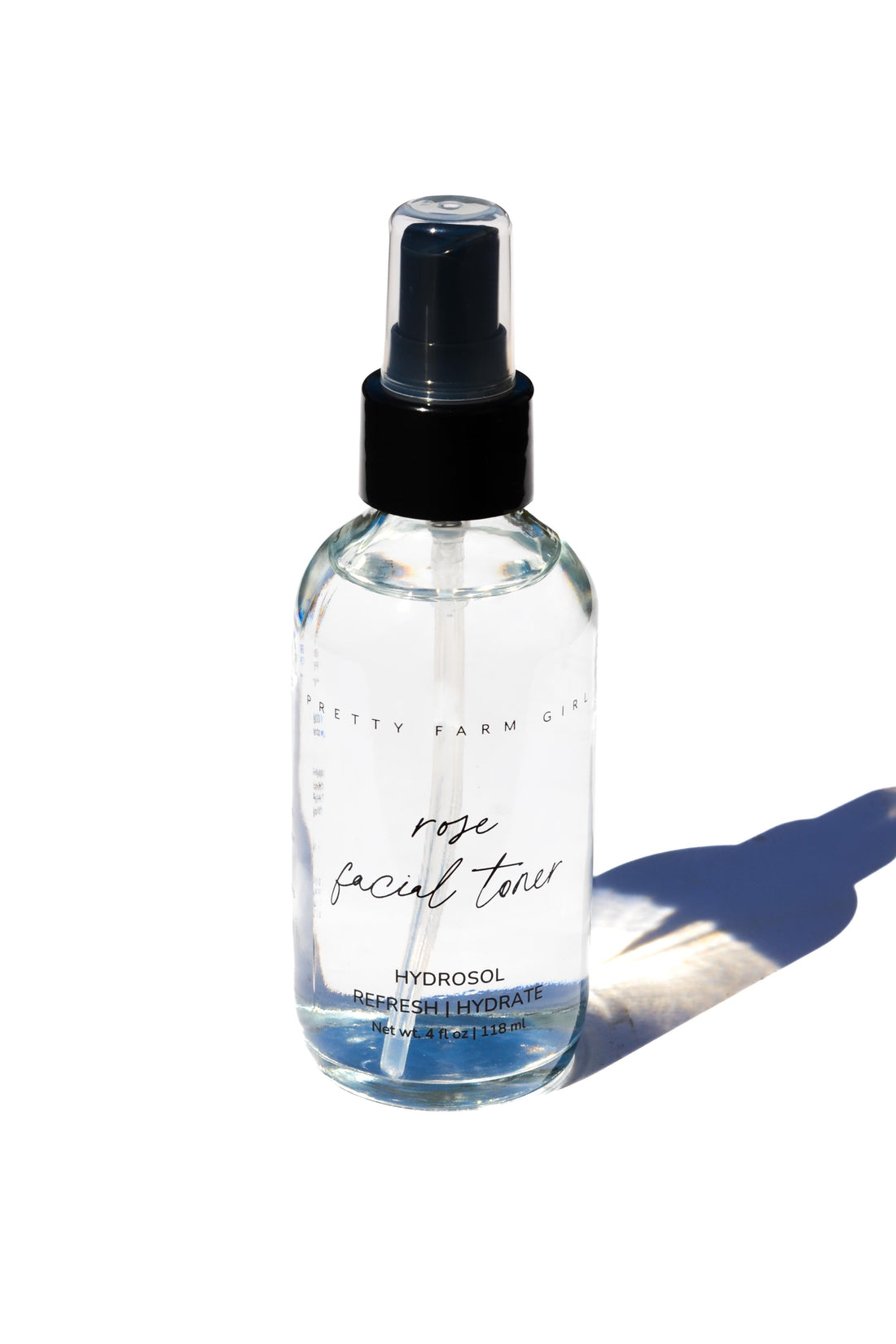 Organic Pure Rose Facial Toner by Pretty Farm Girl in a clear bottle with rose petals and natural ingredients visible.