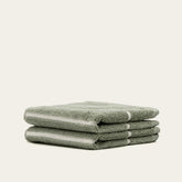 Two Deia Australian cotton washcloths from Italic, soft and plush, displayed on a bed for home and bath use.