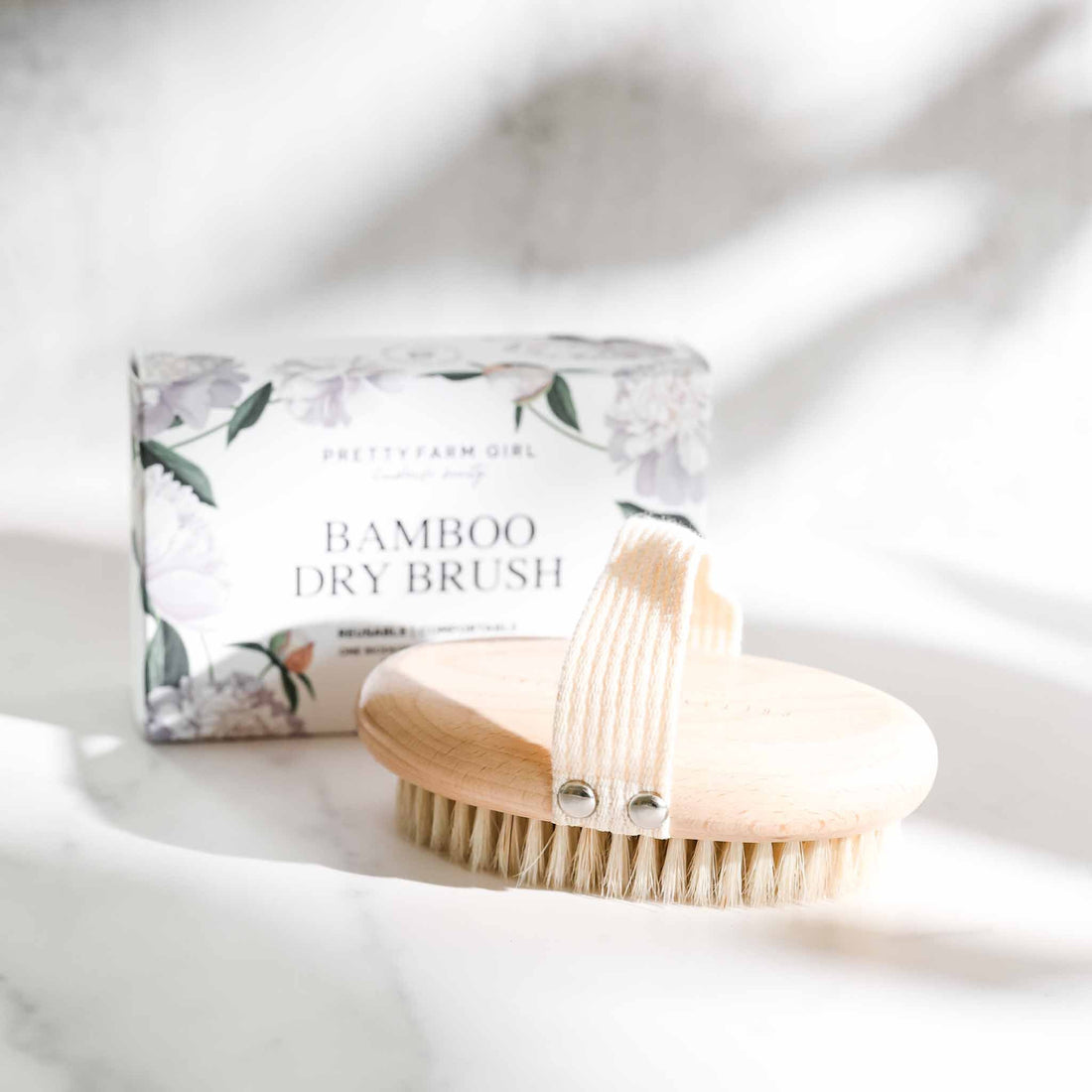 Pretty Farm Girl dry body brush, a natural skincare accessory with wooden handle and bristles for exfoliating skin.
