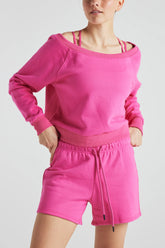 Pink off-shoulder sweatshirt from Fitkitty Culture athleisure wear, featuring a relaxed fit and cozy fabric.
