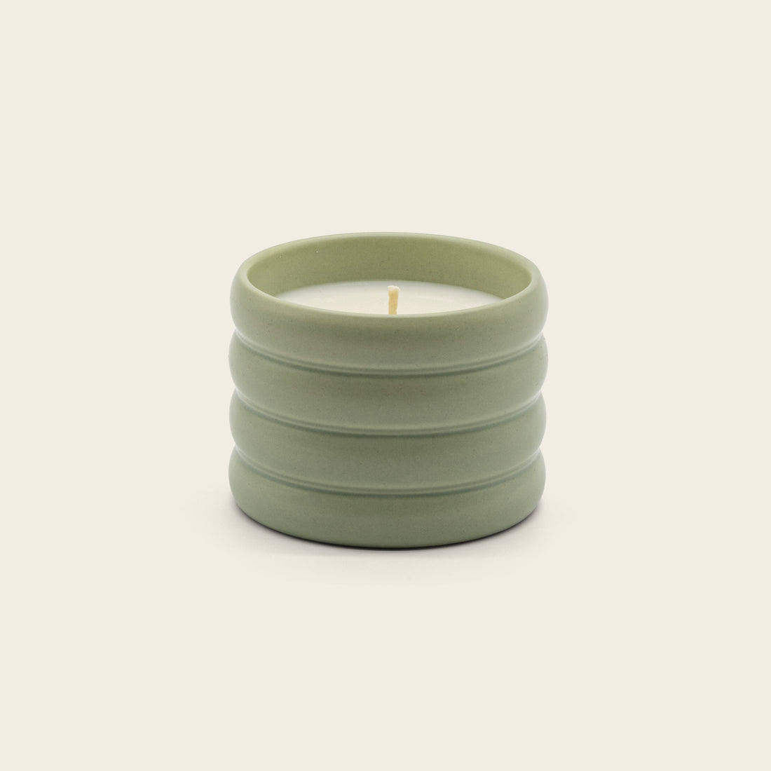Italic soy wax ceramic candle with a white ceramic holder and a lit wick, highlighting a cozy and minimalist design.