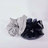 Reflective scrunchies with pockets by Fitkitty Culture, designed for yoga and activewear, shown in a two-pack with a summer background