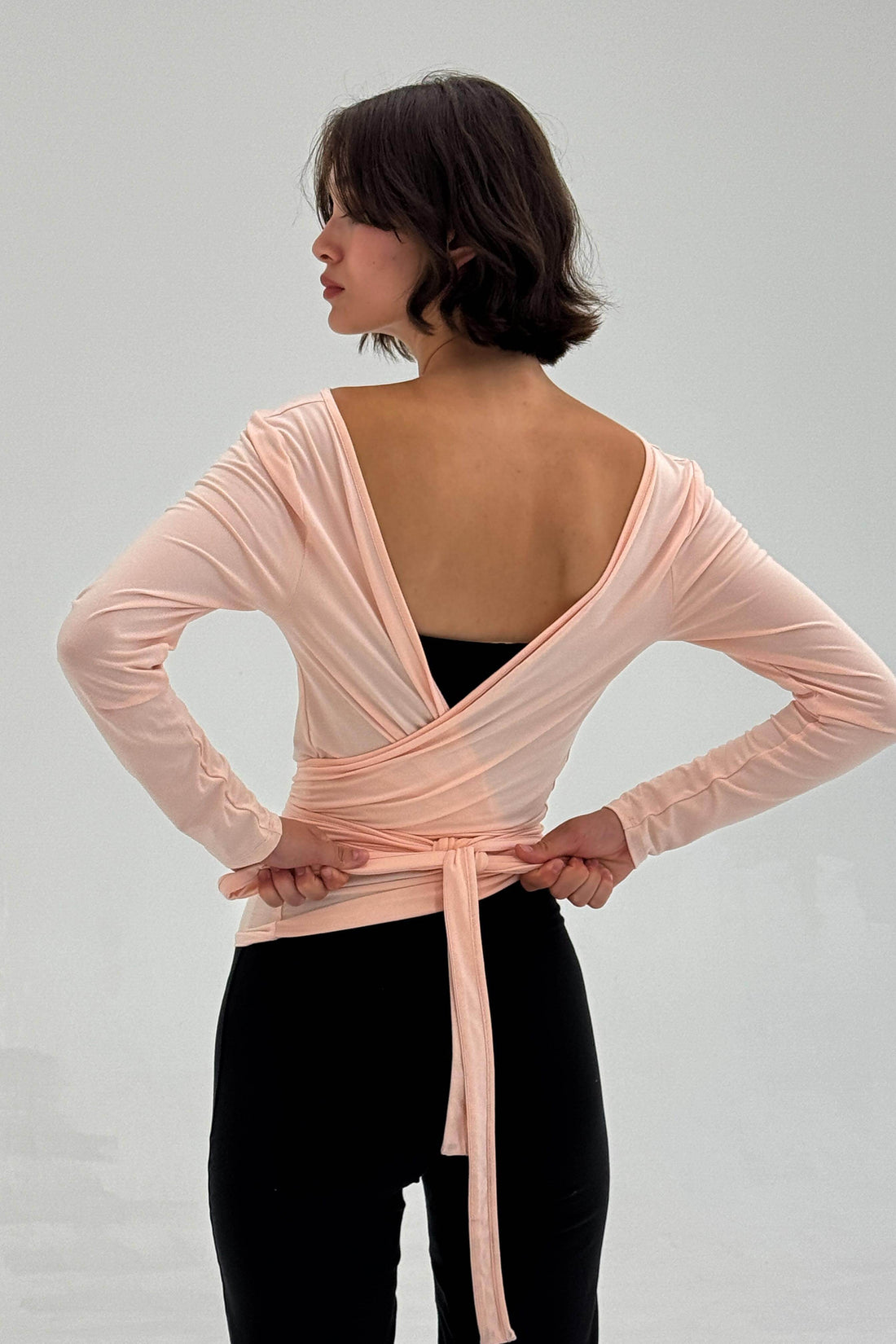Powder pink ballerina wrap top by findmenowthelabel, featuring a soft, fitted design with long sleeves and a stylish wrap detail.