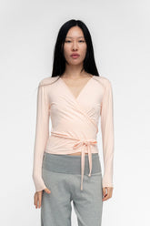 FindmeNowTheLabel ballerina wrap top in powder pink, soft fabric with a fitted silhouette and elegant neckline.