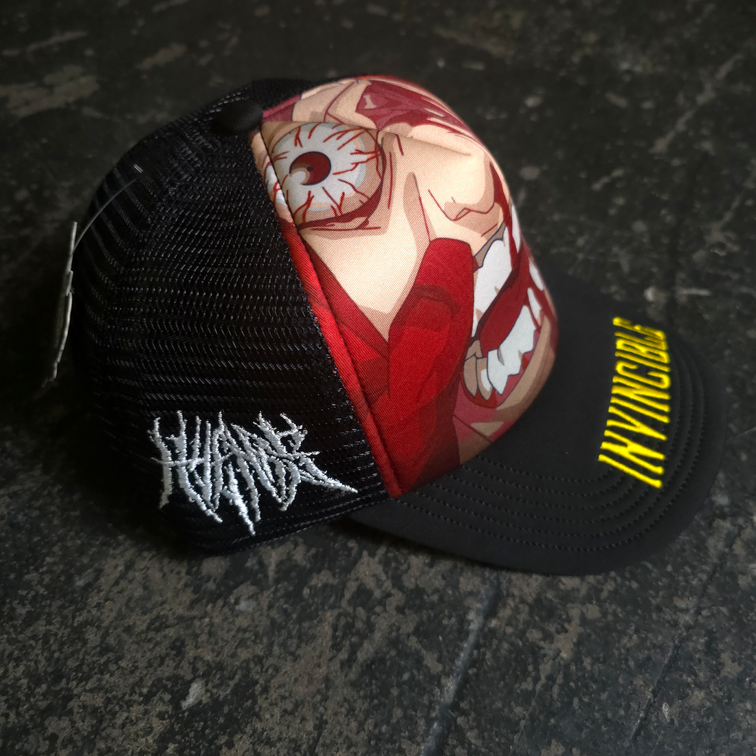 Black Face Smasher Trucker Hat by Any Means Necessary Clothing with a mesh back and bold front design.