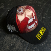 Black trucker hat with face crush graphic, adjustable snapback, and breathable mesh panels by Any Means Necessary Clothing.