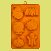 Orange silicone Halloween pet treat mold by Farm To Pet featuring spooky pumpkin and ghost shapes for making pet treats.