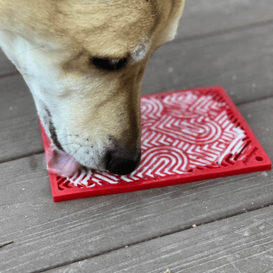 Close-up of Farm To Pet Lick Mat for cats and small dogs, featuring red hearts and a textured surface for licking fun.