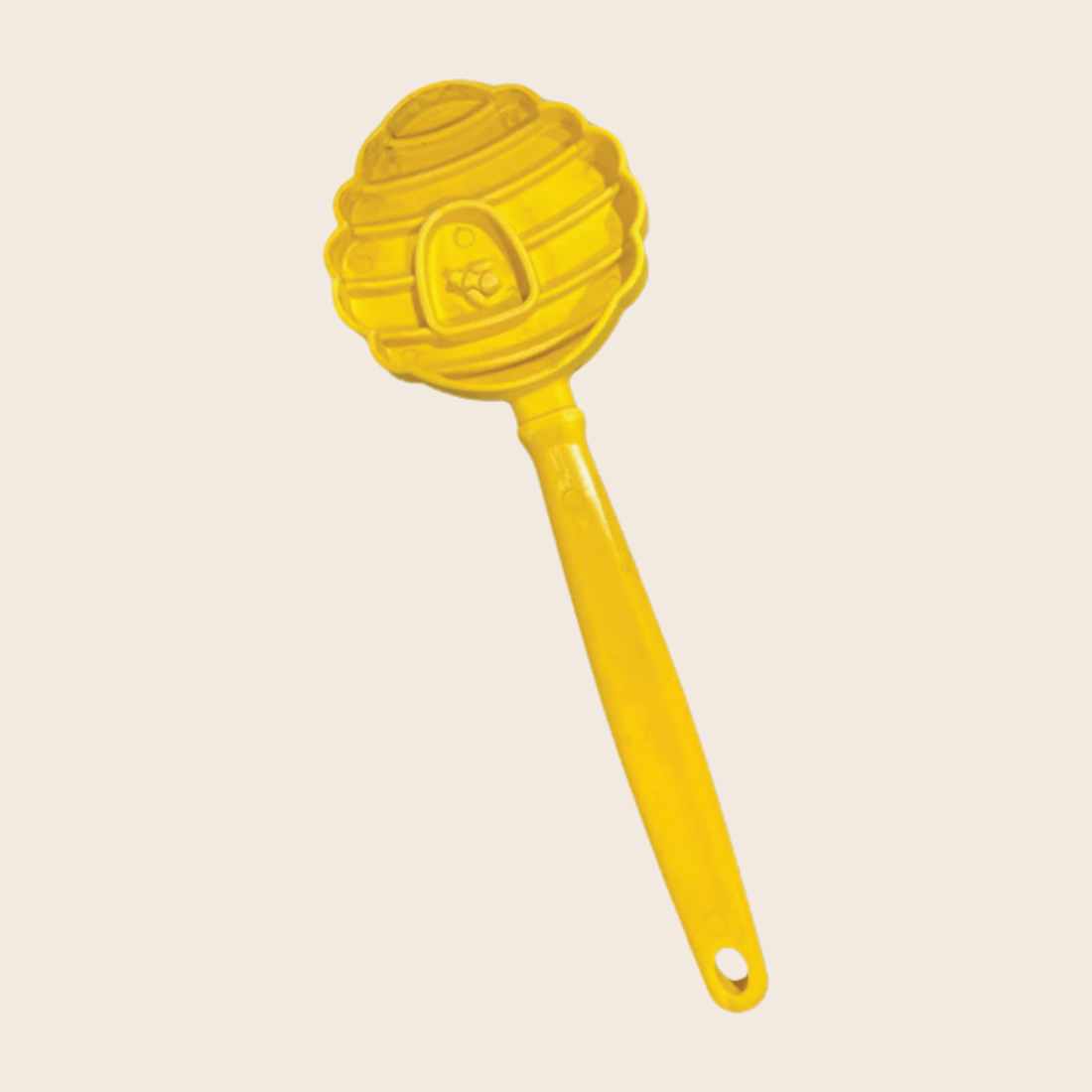 Close-up of Farm To Pet Lick Stick, an interactive dog training toy in yellow with beehive design, for engaging pets.
