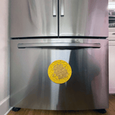 Yellow Farm To Pet round dog lick mat with suction cups featuring duck designs, attached to a refrigerator.