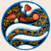 Blue Farm To Pet slow feeder dog bowl with wave design, filled with food, designed to slow dogs while eating.