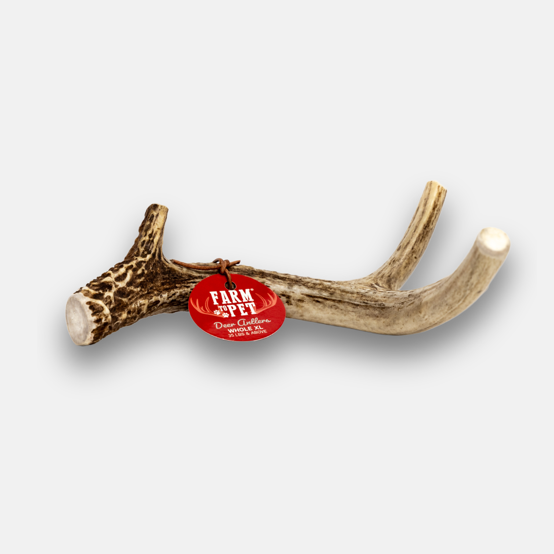 Organic deer antler dog chew from Farm To Pet, showing a large shed antler suitable for dogs, natural and textured with bark.