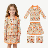 Girl wearing a mustard floral long sleeve pullover skirt set by Mini Rodeo, featuring a stylish top and matching skirt.