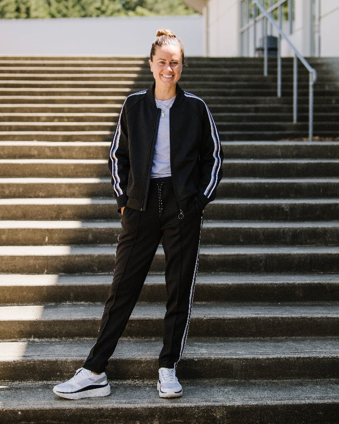 Goal Five Powerstripe mid-rise 28-inch track pant in 7/8 length, lifestyle image showing comfortable athletic leggings.