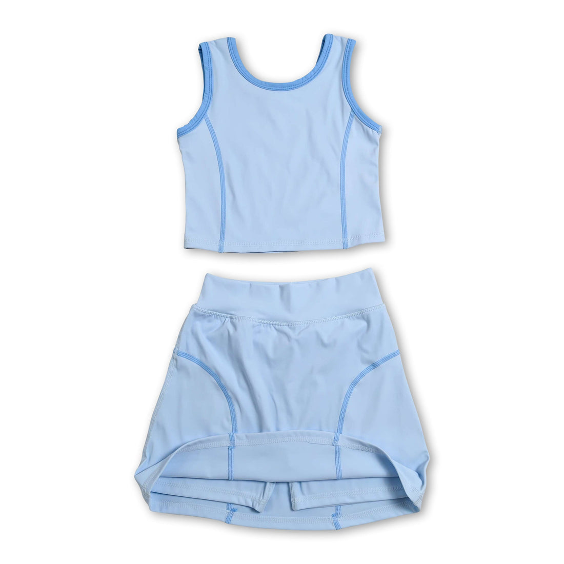 Girl wearing a sleeveless aqua top and high-waist skirt activewear set by Mini Rodeo, showing the coordinated short-sleeve top and skirt.