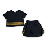 Girl wearing a black cotton short sleeve top and matching skirt set by Mini Rodeo, suitable for team outfits, shown in this image.