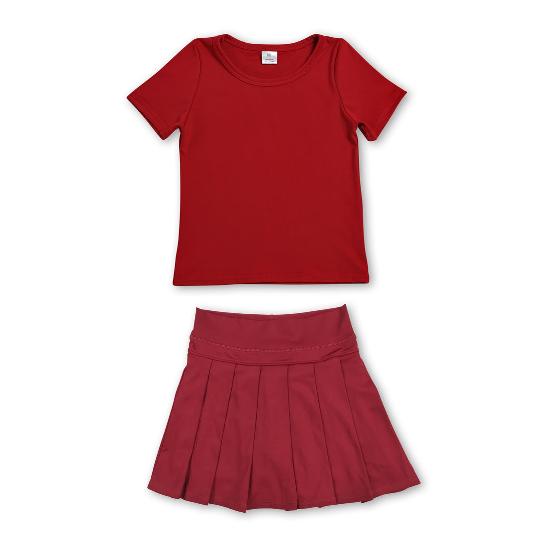 Girl in red short sleeves top and pleated skirt active wear set by Mini Rodeo, perfect for casual and active outings.