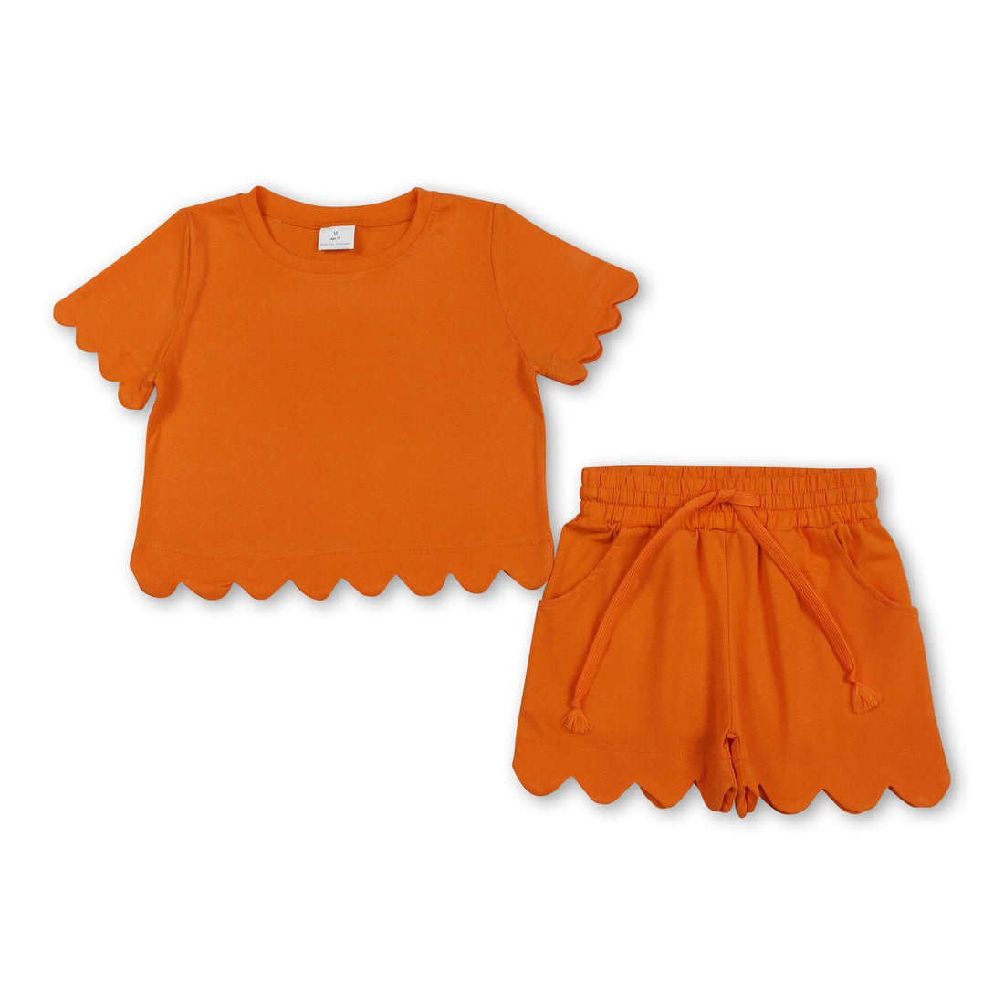 Girl wearing Mini Rodeo short sleeve orange scallop top and shorts set, perfect for summer, front view showing stylish scallop details.