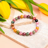 Rainbow Tourmaline bracelet from Conscious Items called The Spiral Breaker, featuring colorful, polished gemstone beads.