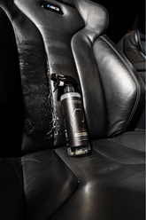 Blackline Car Care BLACKLINE® Gentle APC all-purpose cleaner cleaning a car seat with a spray bottle and microfiber cloth.