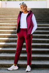 Goal Five Powerstripe mid-rise 28-inch track pants in Merlot, lifestyle image showing relaxed fit and sporty style.