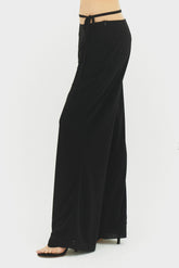 Black Emilia pants by findmenowthelabel, tailored fit with sleek fabric, shown on a model in a casual urban setting.
