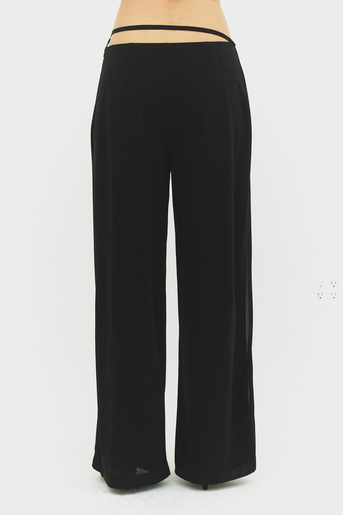 Black Emilia pants from findmenowthelabel, showing a close-up of the tailored fit and fabric texture.